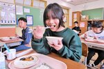鳥取牛を使ったメニューを笑顔で頬張る児童＝１５日、鳥取市六反田の湖南学園
