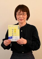 著書を手に「個展は自分を見つめ直す機会になる」と話す竹氏さん
