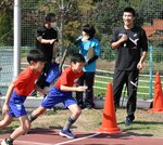 桐生選手（右）にスタートダッシュを学ぶ児童ら＝１５日、鳥取市松上の明治小