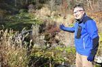 　戦争末期に朝鮮人が動員された「群馬鉄山」があった「チャツボミゴケ公園」で解説する川口正昭さん＝２０２４年１１月、群馬県中之条町