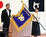 足羽教育長（左）から校旗を受け取った山口校長＝１２日、鳥取市湖山町北５丁目の鳥取県教育センター