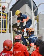 　船上で行われた訓練で、けが人役の男性を運ぶ「ピースウィンズ・ジャパン」のスタッフ＝３月、愛媛県今治市沖