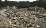 　がれきでうめつくされた岩手県釜石市鵜住居町。左奥は釜石東中、右奥は鵜住居小の校舎＝２０１１年３月２３日（同市提供）
