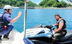 水上バイクの利用者（右）にルール順守を呼びかける関係者＝７日、新温泉町の諸寄海岸