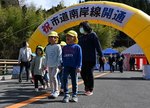 開通した市道南岸線を通り初めする園児や関係者＝２２日、鳥取市佐治町古市