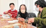 手順を教え合いながら、北欧の伝統的な装飾「ヒンメリ」を完成させる参加者＝３０日、新温泉町湯の町民センター