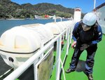救命いかだを点検する船舶検査官＝２２日、境港市大正町