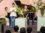 山城裕子さん（左端）が弾くピアノに合わせて生け花のパフォーマンスを披露した山城代利甫さん（右端）