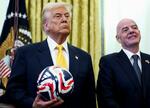 　サッカーボールを手にＦＩＦＡのインファンティノ会長（右）と並ぶトランプ米大統領＝３月７日、ワシントン（ロイター＝共同）