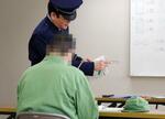 　刑務官（奥）から学習指導を受ける受刑者の男性＝３月、北海道月形町の月形刑務所（画像の一部を加工しています）