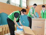 個々に居住スペースが求められるスフィア基準を意識して簡易ベッドを組み立てる参加者＝１６日、鳥取市北村の東郷体育館