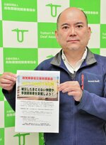 能登半島地震で被災した聴覚障害者への支援を呼びかけるチラシを手にする石橋事務局長＝米子市旗ケ崎６丁目の鳥取県聴覚障害者協会