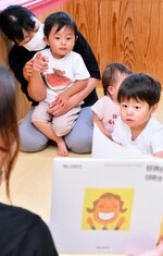 在園児と一緒に絵本を楽しむ、森下さんの長男（左上）＝１日、鳥取市上味野の美和保育園