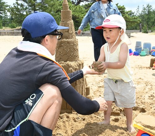 親子で砂遊びを楽しむ子ども（右）＝３１日、鳥取市浜坂の鳥取砂丘フィールドハウス