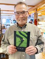 　制作した写真集を持つ望月政男さん