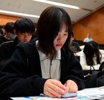 スマートフォンを使ってクイズに解答する学生
