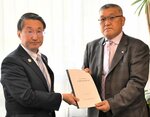 定期監査の結果報告書を平井知事（左）に手渡す桐林正彦代表監査委員＝２８日、鳥取県庁