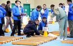 　ボーリング調査の試料を調べる原子力規制委の山岡耕春委員（中央手前）ら＝１７日午前、静岡県御前崎市