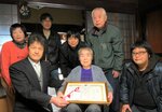 親族らに囲まれ、１００歳の祝い状を受け取った藤沢さん（前列中央）＝１６日、香美町小代区水間