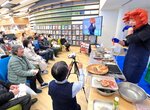 図書館内でカニを使った多彩なメニューを紹介する浜野さん