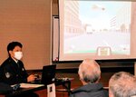 動画を見せながら危険箇所を解説する警察官＝８日、八頭町宮谷の郡家老人福祉センター