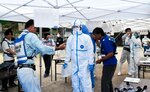 防護服やゴーグルなどの着脱、動線確認をする参加職員＝２７日、智頭町大背の旧那岐小