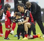 　ライプチヒ戦終了後、娘（左）と息子を抱き寄せるＥフランクフルトの長谷部＝１８日、フランクフルト（共同）