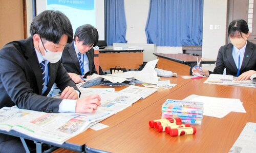 オリジナルのスクラップ新聞を作るために記事を選んで切り抜く新入職員ら