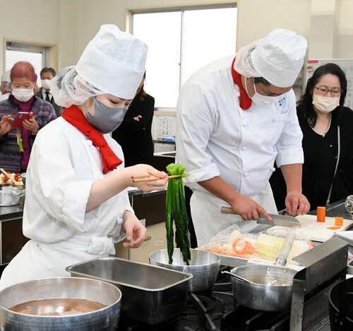 保護者が見守る中、料理の腕を振るう生徒ら