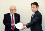 　外務省の中村仁威軍縮不拡散・科学部長（右）に要請文を手渡す被団協代表委員の田中熙巳さん＝１７日午前、東京都千代田区