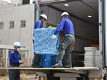 　梱包された「火星の石」をトラックに運び込む作業員＝２６日午後、東京都立川市