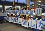 　「のと鉄道」が全線再開し、メッセージを示す作業員ら＝４月６日早朝、石川県穴水町