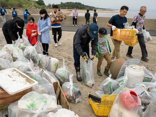 拾い集めたごみを１カ所に集める参加者＝１３日、米子市両三柳