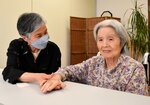 母の今村さん（右）の手を握る大橋さん＝１８日、鳥取市湖山町西３丁目の特別養護老人ホーム「いこいの杜」
