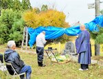 読経が流れる中、供養碑前で手を合わせる参列者＝３０日、新温泉町前