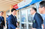 境港市役所に到着し、歓迎を受ける文副市長（左から２人目）＝２７日、境港市上道町