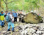 神のよりしろとされる磐座とその周辺の遺跡に関する解説を聞く参加者ら＝４日、三朝町神倉