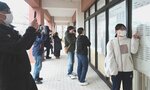 自分の受験番号が書かれた掲示の前で記念写真を撮る合格者ら＝６日、鳥取市湖山町南４丁目の鳥取大
