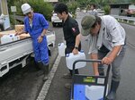 鳥取市の職員が運んできた水を車両に積み込む住民