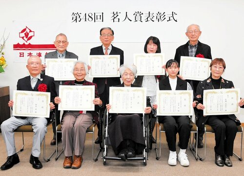 賞状を手に喜ぶ受賞者＝７日、鳥取市富安２丁目の新日本海新聞社
