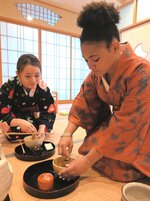 茶道部員に教えてもらいながら抹茶をたてるバーンズさん（右）＝２９日、鳥取市若葉台北１丁目の鳥取環境大