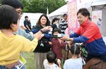 乳酸菌飲料の試飲をする親子連れ＝３１日、鳥取市浜坂のアイエム電子鳥取砂丘こどもの国