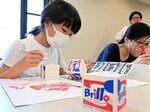 見本を見ながらデザインロゴやオリジナルイラストなどを描く参加者＝１７日、鳥取市東町の県立博物館