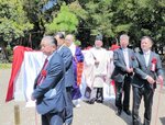 三葉松を囲む玉垣前で除幕する関係者