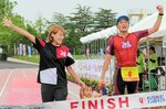初の頂点に立った高橋正俊（右）。真紀さん（左）、蘭ちゃん（中央）と一緒にフィニッシュ＝１４日、米子市のどらドラパーク米子陸上競技場