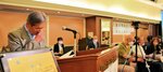 認知症の人と家族の会総会で言葉を詰まらせる荒川勉さん（左）＝６月８日、京都市