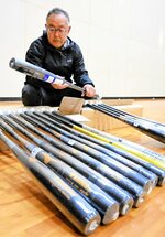 日本高野連から届いたバットを検品する田村理事長＝県高野連