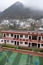 　断崖の上にある官寨小学校＝２０２５年３月、中国雲南省宣威市（共同）
