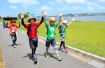両手を挙げて喜びを表し、風光明媚な東郷池周辺を歩くウオーカー＝３日、湯梨浜町長和田
