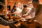 食べると無病息災になるとされる御供を、「打ち神」（右）から受け取る参加者